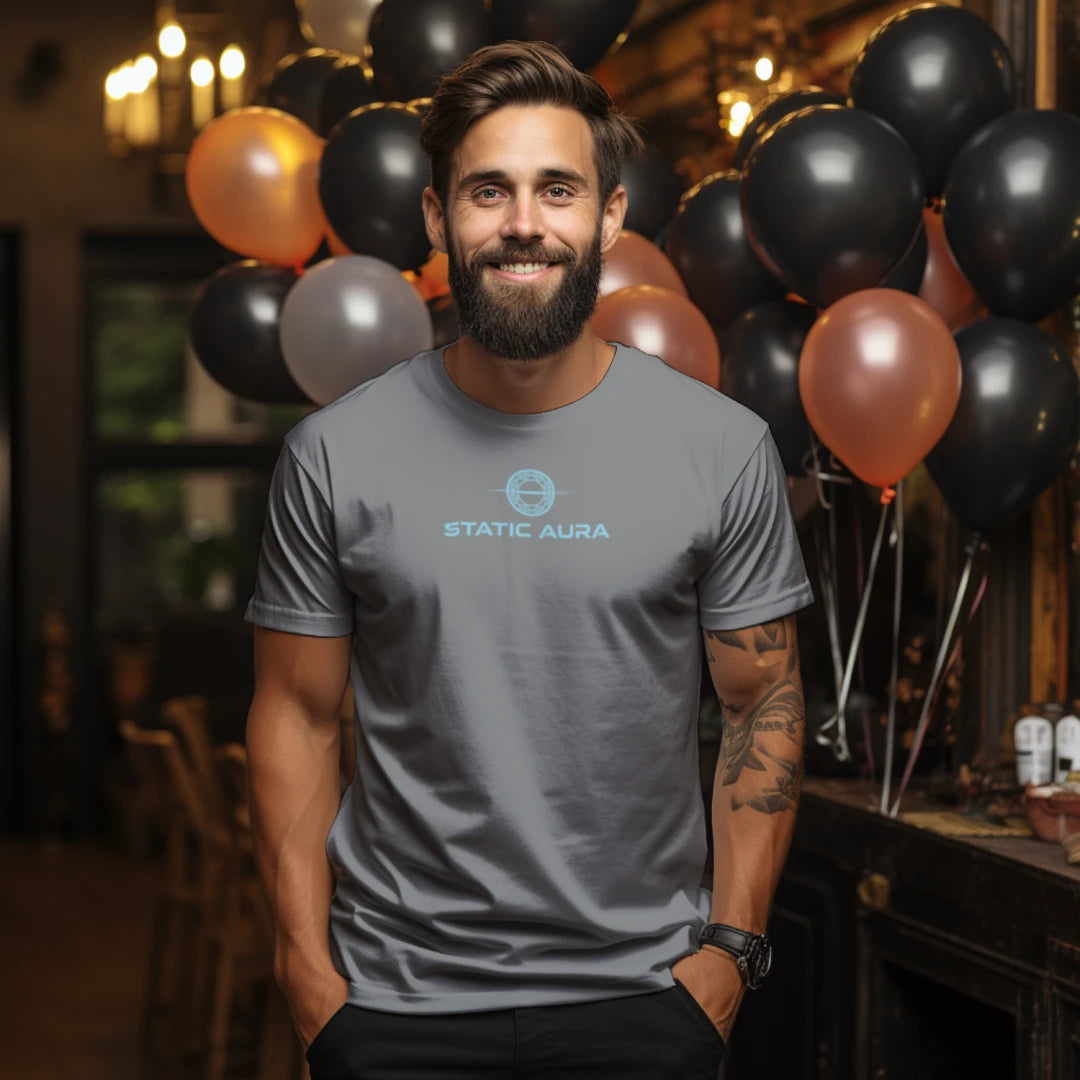 Man wearing a gray t-shirt with 'Static Aura' logo in a festive setting with balloons.