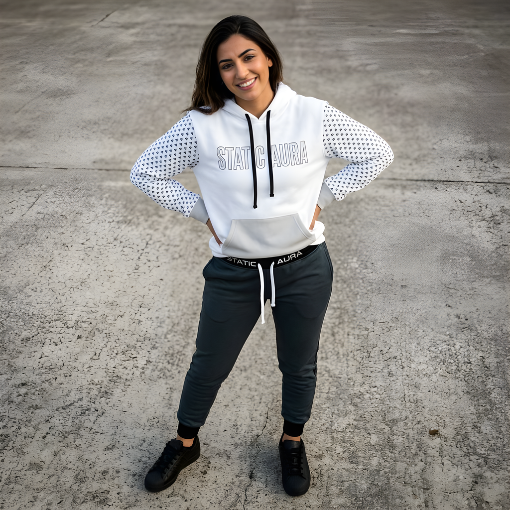Woman wearing a white hoodie with 'Static Aura' branding on a concrete surface